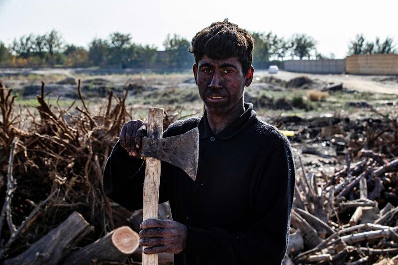 A worker with the axe he uses to cut wood for charcoal making in rural Raqqa, northern Syria. Photos: AFP