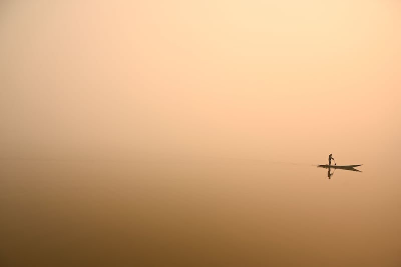 A man steers a boat in Dal Lake amid a thick blanket of fog in Srinagar. AFP

