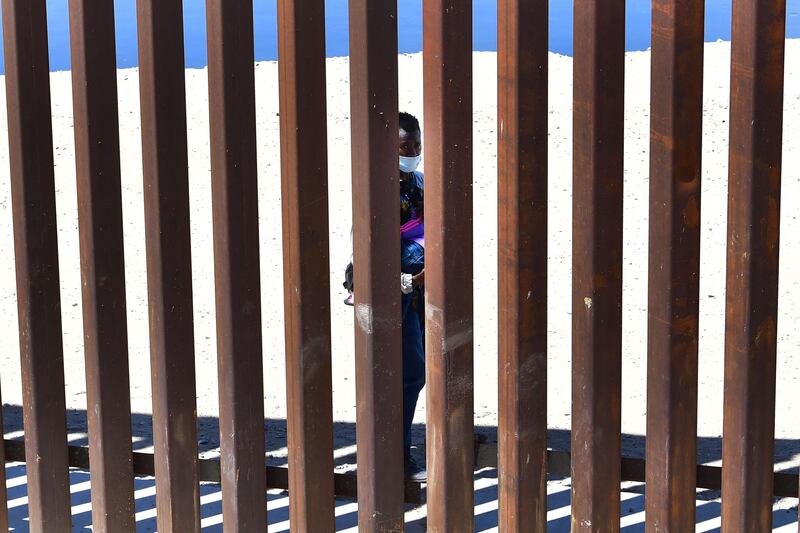 A migrant walks on the Mexico side of the border wall across from Yuma, Arizona.  AFP