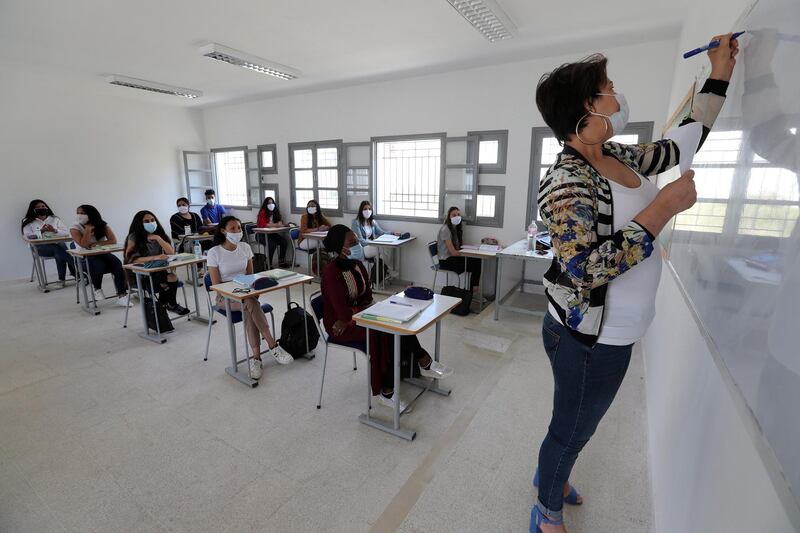 A teacher wearing face mask gives a lesson at a classroom at 'Riadh' high school, in La Marsa in the suburbs of Tunis, Tunisia, after authorities approved the easening of measures put in place due to the coronavirus pandemic. EPA