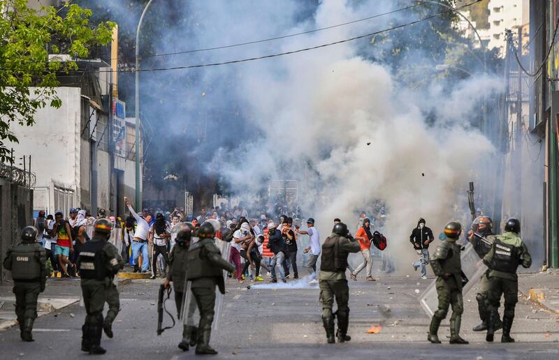 Riot police clash with opposition demonstrators in Caracas. AFP