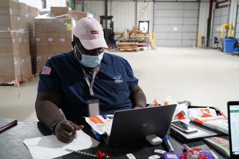 A worker at Mako Medical Laboratories registers a FedEx package full of PCR tests. Willy Lowry / The National