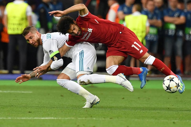 Liverpool's Egyptian forward Mohamed Salah (R) falls with Real Madrid's Spanish defender Sergio Ramos leading to Salah being injured during the UEFA Champions League final football match between Liverpool and Real Madrid at the Olympic Stadium in Kiev, Ukraine, on May 26, 2018. (Photo by GENYA SAVILOV / AFP)