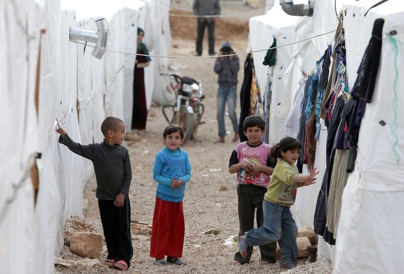 Syrian children play outside their tents at a refugee camp in the city of Arsal in Lebanon's Bekaa valley. Joseph Eid / AFP
