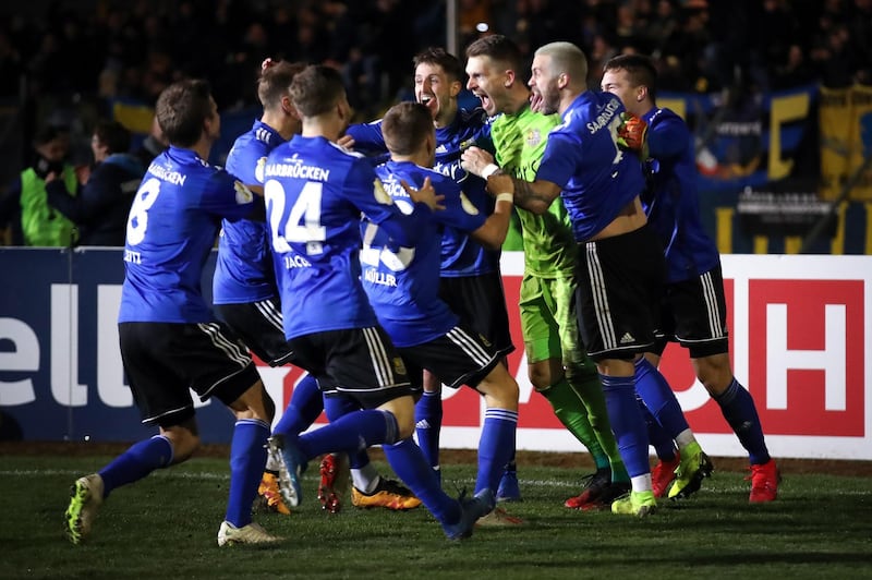 VOELKLINGEN, GERMANY - MARCH 03: Goalkeeper Daniel Batz of Saarbruecken celebrates with team mates after saving a penalty from Mathias Zanka Jørgensen of Fortuna Dusseldorf to give his side victory during the DFB Cup quarterfinal match between 1. FC Saarbruecken and Fortuna Duesseldorf at Hermann-Neuberger-Stadion on March 03, 2020 in Voelklingen, Germany. (Photo by Alex Grimm/Bongarts/Getty Images)