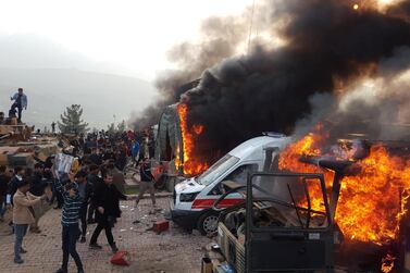 Smoke rises from burning vehicles after protesters stormed a Turkish military camp near Dohuk, Iraq, on January 26. Reuters 