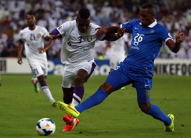 Al Hilal defender Digao, right, defends  Al Ain forward Asamoah Gyan during their AFC Champions League semi-final match on September 30, 2014 at Hazza Bin Zayed Stadium in the UAE. AFP PHOTO/MARWAN NAAMANI