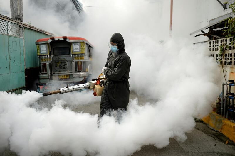 A worker in a hazmat suit disinfects a street as a preventive measure against the spread of coronavirus disease at a village in Manila, Philippines. Reuters