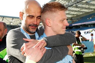 Manchester City manager Pep Guardiola embraces Oleksandr Zinchenko as they celebrate winning the Premier League on Sunday. Getty Images