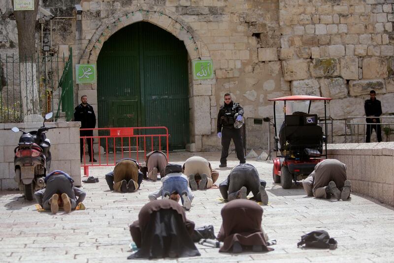 Palestinians pray in front of the shuttered gates to al-Aqsa mosque compound as all prayers are suspended to prevent the spread of coronavirus in Jerusalem, on March 23, 2020. AP Photo