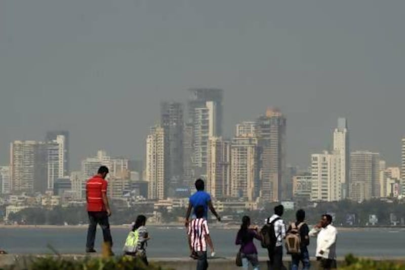 Pedestrians walk on the seaside promenade in Mumbai. Home prices in the city have increased by 66 per cent over the past four years. Punit Paranjpe / AFP