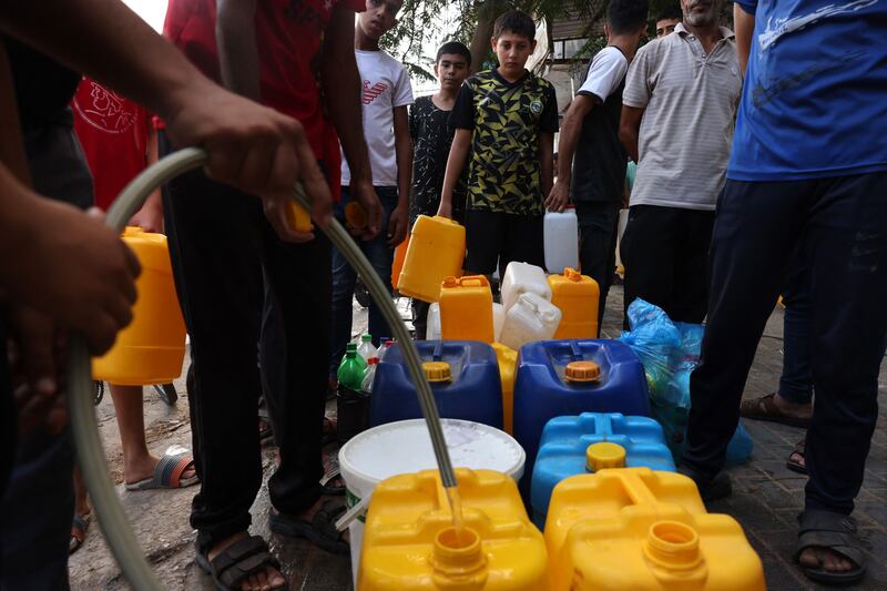 Palestinians queue to refill water containers at Rafah refugee camp in southern Gaza. AFP