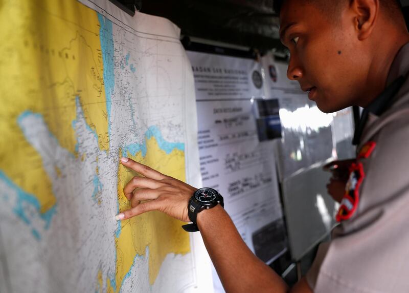 An Indonesian police officer studies a map in the search and rescue command centre at Tanjung Priok port. Reuters