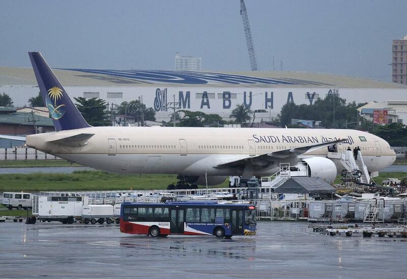 A passenger bus passes by the Saudi Arabian Airlines plane Flight SV872 from Jeddah as it stays at an isolated area at Manila's International Airport in Pasay, south of Manila, Philippines on Tuesday, September 20, 2016. Aaron Favila / AP Photo