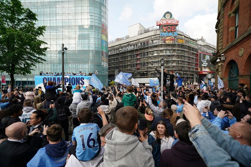 Fans line the streets of Manchester for the open-top bus parade. AP
