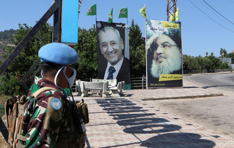 A United Nations peacekeeper (UNIFIL) stands near a poster depicting Lebanon's Hezbollah leader Sayyed Hassan Nasrallah, in Adaisseh village, near the Lebanese-Israeli border, Lebanon August 7, 2020. REUTERS/Karamallah Daher