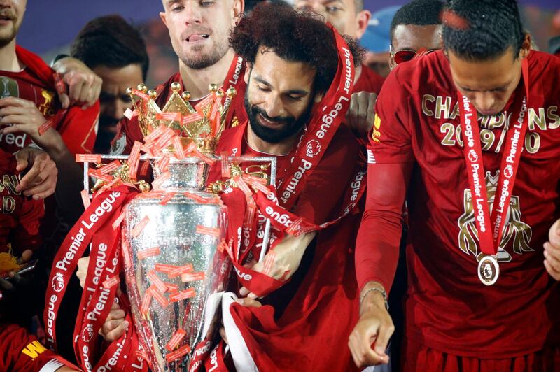 Liverpool's Mohamed Salah celebrates with the Premier League trophy after the Premier League match at Anfield, Liverpool. PA Photo. Picture date: Wednesday July 22, 2020. See PA story SOCCER Liverpool. Photo credit should read: Phil Noble/NMC Pool/PA Wire. RESTRICTIONS: EDITORIAL USE ONLY No use with unauthorised audio, video, data, fixture lists, club/league logos or "live" services. Online in-match use limited to 120 images, no video emulation. No use in betting, games or single club/league/player publications.