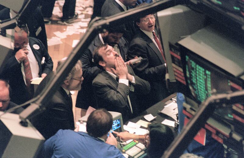 A trader (c) on the New York Stock Exchange looks at stock rates 19 October 1987 as stocks were devastated during one of the most frantic days in the exchange's history.  The Dow Jones index plummeted over 200 points in record trading. / AFP PHOTO / MARIA BASTONE