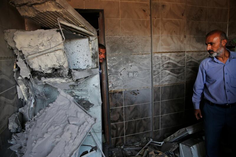 Halil Tokak, right, the neighborhood chief and another resident, inspect the damage on a house, caused by a mortar fired from inside Syria, on the Turkish town of Akcakale, southeastern Turkey. Nobody got hurt by the attack as the owners of the house were not at home at the time of the attack. AP Photo