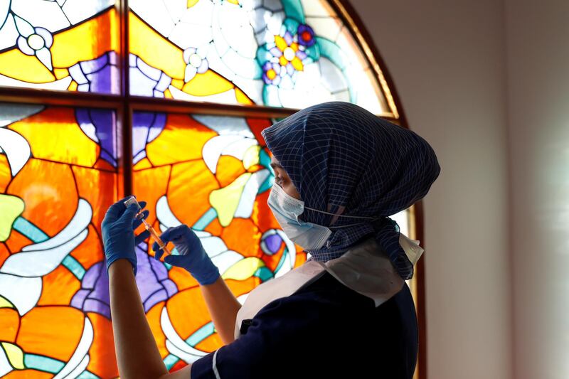 Nurse Zenub Mahood prepares a dose of the AstraZeneca vaccine at Bradford Central Mosque, northern England. Reuters