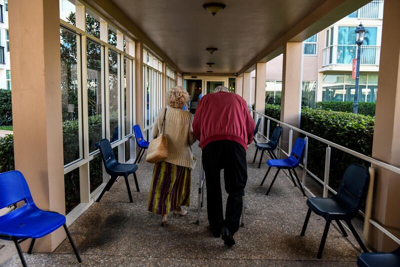 An elderly residents walks inside deserted John Knox Village, a retirement community in Pompano Beach, Florida on March 21, 2020. - Almost one billion people were confined to their homes worldwide as the global coronavirus death toll topped 12,000 and US states rolled out stay-at-home measures already imposed across swathes of Europe. More than a third of Americans were adjusting to life in various phases of virtual lockdown -- including in the US's three biggest cities of New York, Los Angeles and Chicago -- with more states expected to ramp up restrictions. (Photo by CHANDAN KHANNA / AFP)