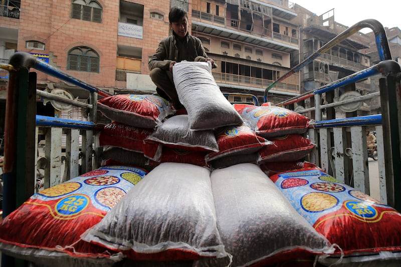 A worker offloads supplies at a shop in Peshawar. Price gains in Pakistan quickened for a third month in February. EPA