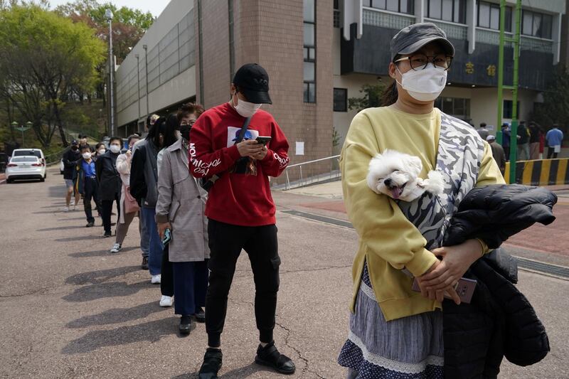 Voters wearing face masks wait in line to cast their ballots at a polling station during the parliamentary election in Seoul, South Korea. Reuters