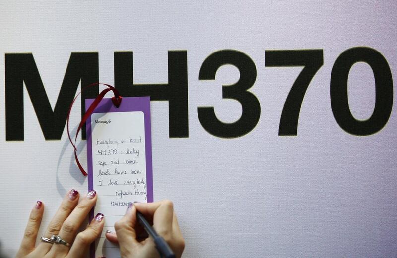 A tourist from Vietnam writes a message expressing hope for family members. Samsul Said / Reuters March 12