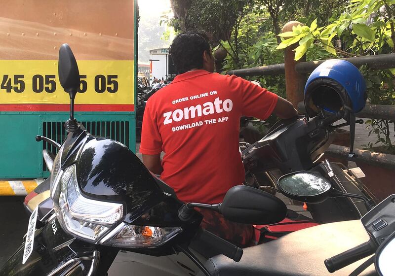 (FILES) In this file photo taken on December 24, 2018 an Indian delivery man working with the food delivery app Zomato sits on his bike in Mumbai. An Indian food service has sparked a national debate and set off a social media storm by defending a Muslim delivery driver who was rejected by a Hindu customer.
 - 
 / AFP / Indranil MUKHERJEE
