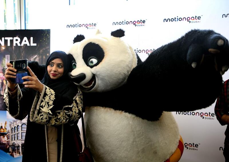 Shaikha al Shamsi, head of destination and marketing at Dubai Parks and Resorts takes a selfie with Panda during a press conference at Reel Cinemas in Dubai. Ravindranath K / The National 