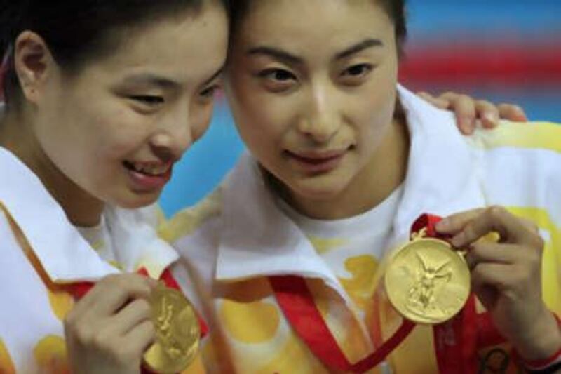 Guo Jingjing, right, and Wu Minxia of China display their gold medals after winning gold in the women's synchronized 3-metre springboard diving.