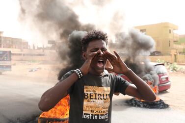 Sudanese men burn tires during a demonstration to commemorate the first anniversary of a deadly crackdown carried out by security forces on protesters during a sit-in outside the army headquarters, in Khartoum, Sudan, Wednesday, June 3, 2020. (AP Photo/ Marwan Ali)