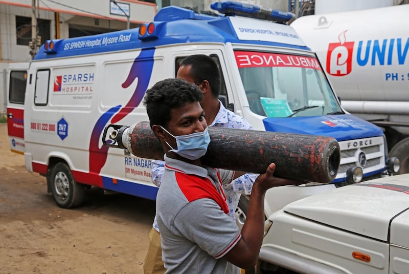 epa09149942 An Indian boy carries an empty oxygen cylinder for filling at oxygen filling center in Bangalore, India, 21 April 2021. There is a shortage of oxygen cylinders in certain COVID-19 affected areas but the Karnataka state government has said that it will do its best to make sure the distribution of liquid medical oxygen is smooth and there will be no shortage.  EPA/JAGADEESH NV