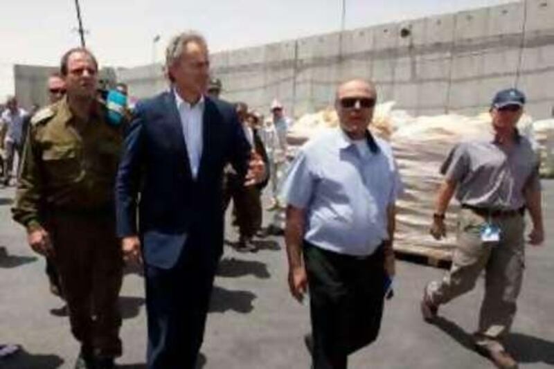 Quartet Middle East envoy Tony Blair (2nd L) visits to the Kerem Shalom terminal between Israel and Gaza, on June 22, 2010. Blair said that he hopes additional easements on the Gaza blockade will be made within the next two weeks and that the gestures will give momentum to the relations between Israel and the Palestinians. AFP PHOTO/JACK GUEZ *** Local Caption ***  833907-01-08.jpg
