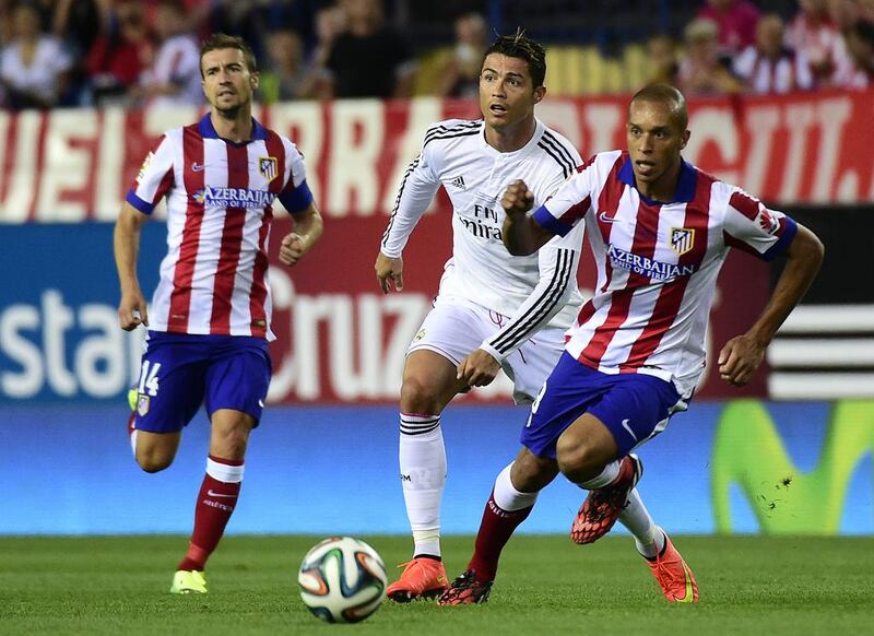 Real Madrid’s Cristiano Ronaldo, centre, in hot pursuit of the ball with Miranda, right, and Gabi of Atletico Madrid last August. The Madrid derby is one of the most eagerly anticipated matches in Spain. Gerard Julien / AFP

