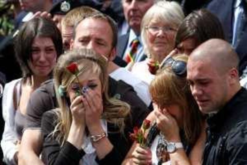 Mourners cry as the hearses containing the bodies of four soldiers, who died in Afghanistan, drive through Wootton Bassett, in Wiltshire, south west England July 28, 2009. Four British soldiers who died whilst serving in Afghanistan were repatriated on Tuesday.   REUTERS/Andrew Winning (BRITAIN CONFLICT MILITARY POLITICS OBITUARY) *** Local Caption ***  AWI02_BRITAIN-_0728_11.JPG *** Local Caption ***  AWI02_BRITAIN-_0728_11.JPG