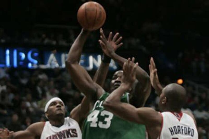 Boston Celtics' Kendrick Perkins, centre, shoots under the basket as Atlanta Hawks forwards Josh Smith, left, and Al Horford try and defend.