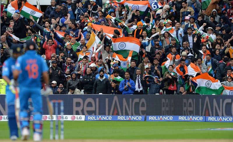 Indian fans celebrate after India's Ravindra Jadeja hit a six during the 2013 ICC Champions Trophy Final cricket match between England and India at Edgbaston in Birmingham, central England on 23, June 2013.  Play in the rain-marred Champions Trophy final between hosts England and world champions India at Edgbaston got underway nearly six hours late. Rain reduced the showpiece match from a 50 overs per side contest to the bare minimum of 20 overs per side required to produced a result, with the fixture, due to get underway at 10.30am local time (0930GMT) finally starting at 4:20pm. AFP PHOTO/ANDREW YATES
 *** Local Caption ***  408460-01-08.jpg