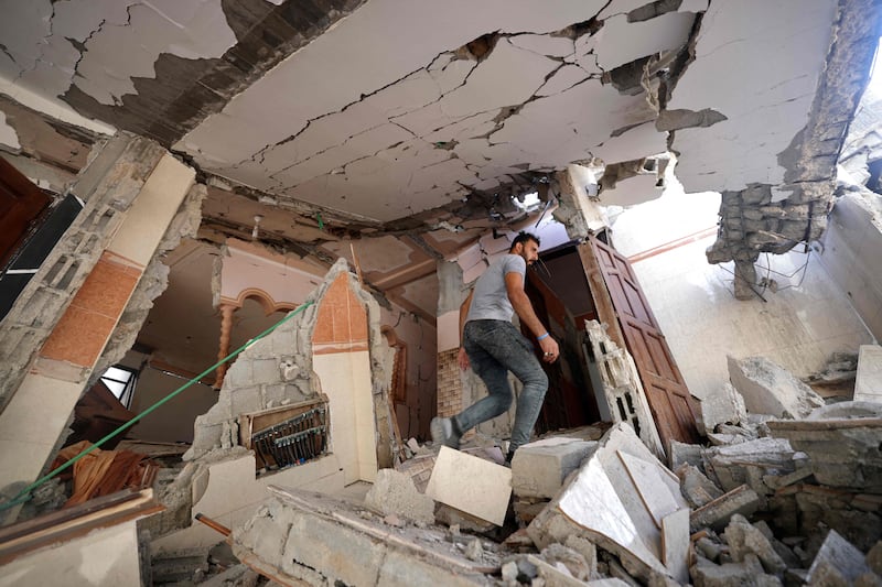 A Palestinian man in the rubble of his badly damaged home, which was struck by Israeli missiles in Gaza City. AFP