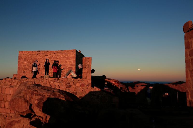 Tourists watch the sun rise and the moon set from Mount Sinai, Egypt. Nariman El Mofty / AP Photo