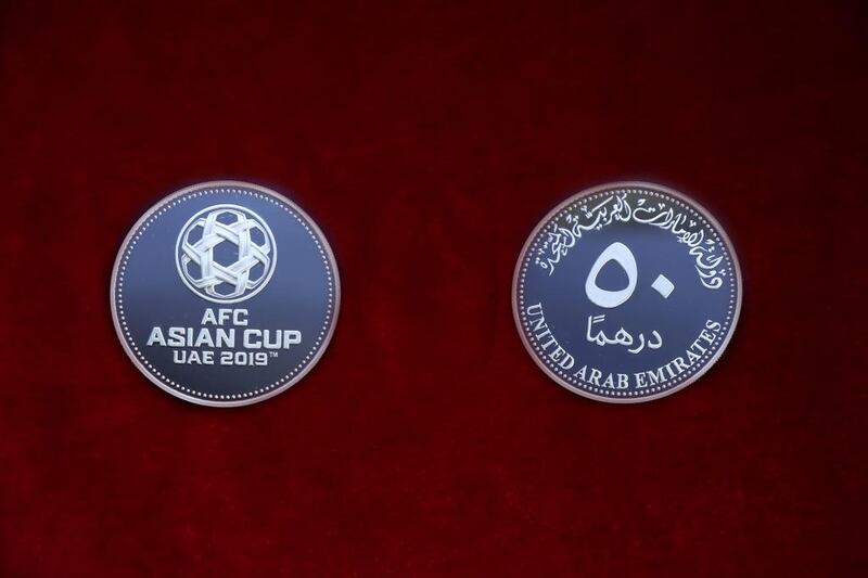 The commemorative silver coin features the Asian Cup logo.