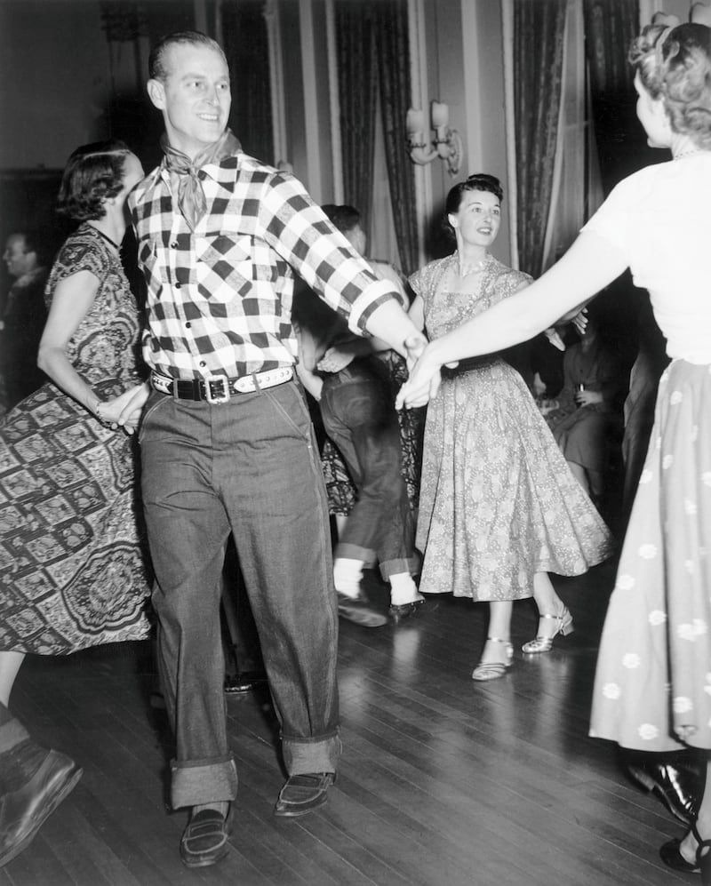 His Royal Highness Prince Philip, Duke of Edinburgh, enjoys an old-fashioned hoedown held in the honour of the Royal Couple at Rideau Hall, Ottawa, Ontario, Canada, October 11, 1951. Photo taken during the National Film Board of Canada's production of 'Royal Journey,' a documentary account of the five-week visit of Princess Elizabeth and the Duke of Edinburgh to Canada and the United States in the fall of 1951. (Photo by Frank Royal/NFB/Getty Images)