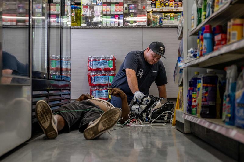 A person receives medical attention after collapsing in a shop in Phoenix, Arizona, in high heat. AFP