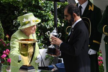 Queen Elizabeth II presents Sheikh Mohammed bin Rashid, Vice President and Ruler of Dubai, with the Diamond Jubilee trophy. Facundo Arrizabalaga / EPA