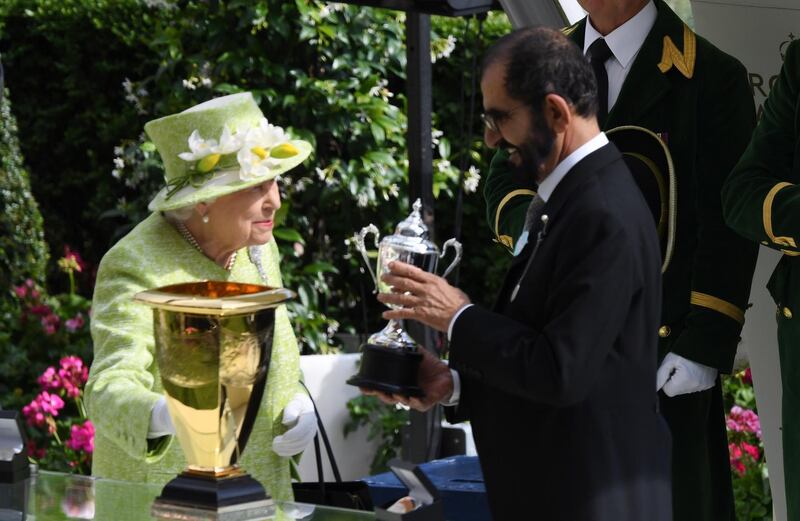 epa07666588 Britain's Elizabeth II presents Dubai's ruler Sheikh Mohammed bin Rashid al-Maktoum with a trophy for the winning owner of the 4.20 Diamond Jubilee Stake during the final day of Royal Ascot in Ascot, Britain, 22 June 2019. Royal Ascot is Britain's most valuable horse race meeting and social event running daily from 18 to 22 June 2019.  EPA/FACUNDO ARRIZABALAGA