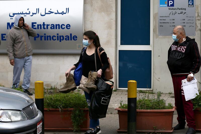 People wear face masks outside of the Rafik Hariri University Hospital where a woman is treated for coronavirus, the first case in Beirut, Lebanon.  EPA