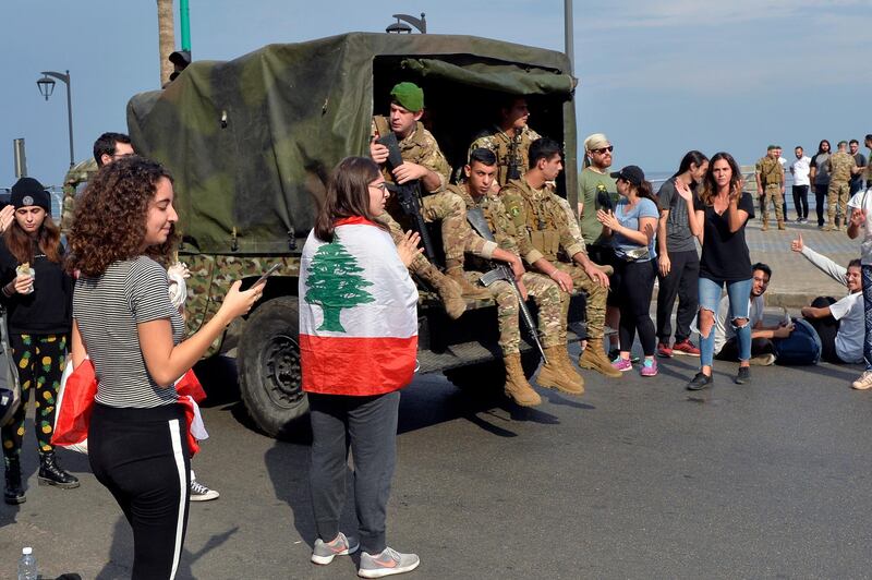 A Lebanese army vehicle drives next to university students as they block the main highway during ongoing anti-government protests at the Corniche al-Manara in Beirut, Lebanon. EPA
