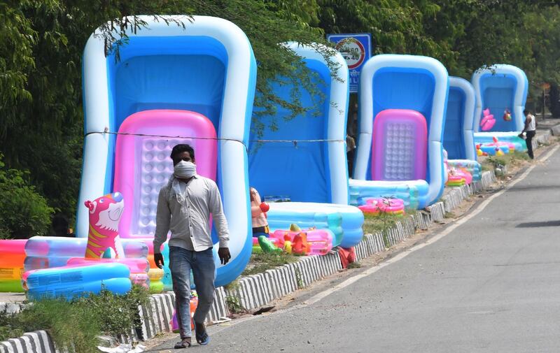 A man walks past inflatable items for sale on a roadside amid an easing of coronavirus lockdown measures, in New Delhi, India.  EPA