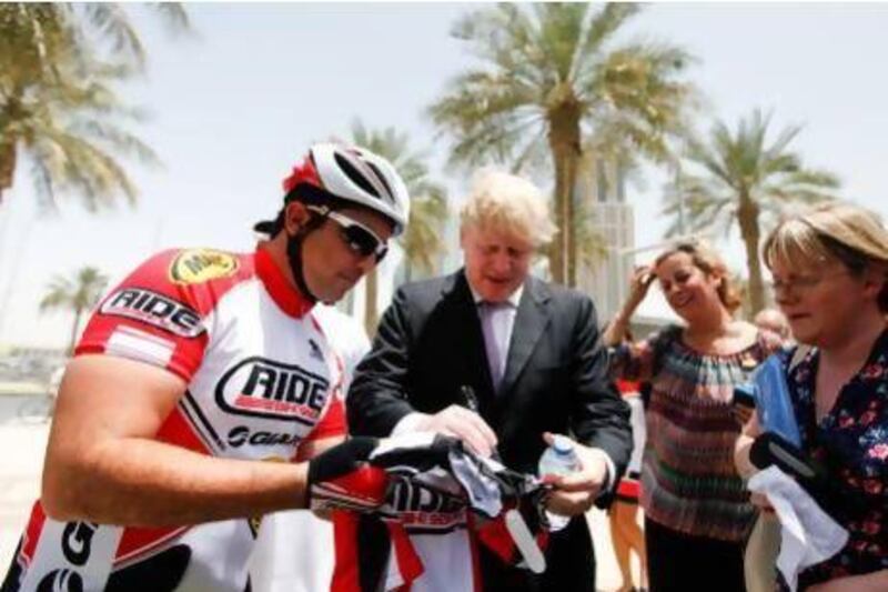 Shahriar Khodjasteh, president of Dubai Desert Extreme, gets a cycling jersey autographed by Mr Johnson. Sarah Dea / The National