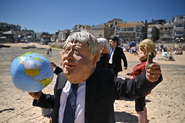 An Extinction Rebellion environmental activist wearing a Boris Johnson mask stages a demonstration during the G7 summit on June 13, in St Ives, England. Getty